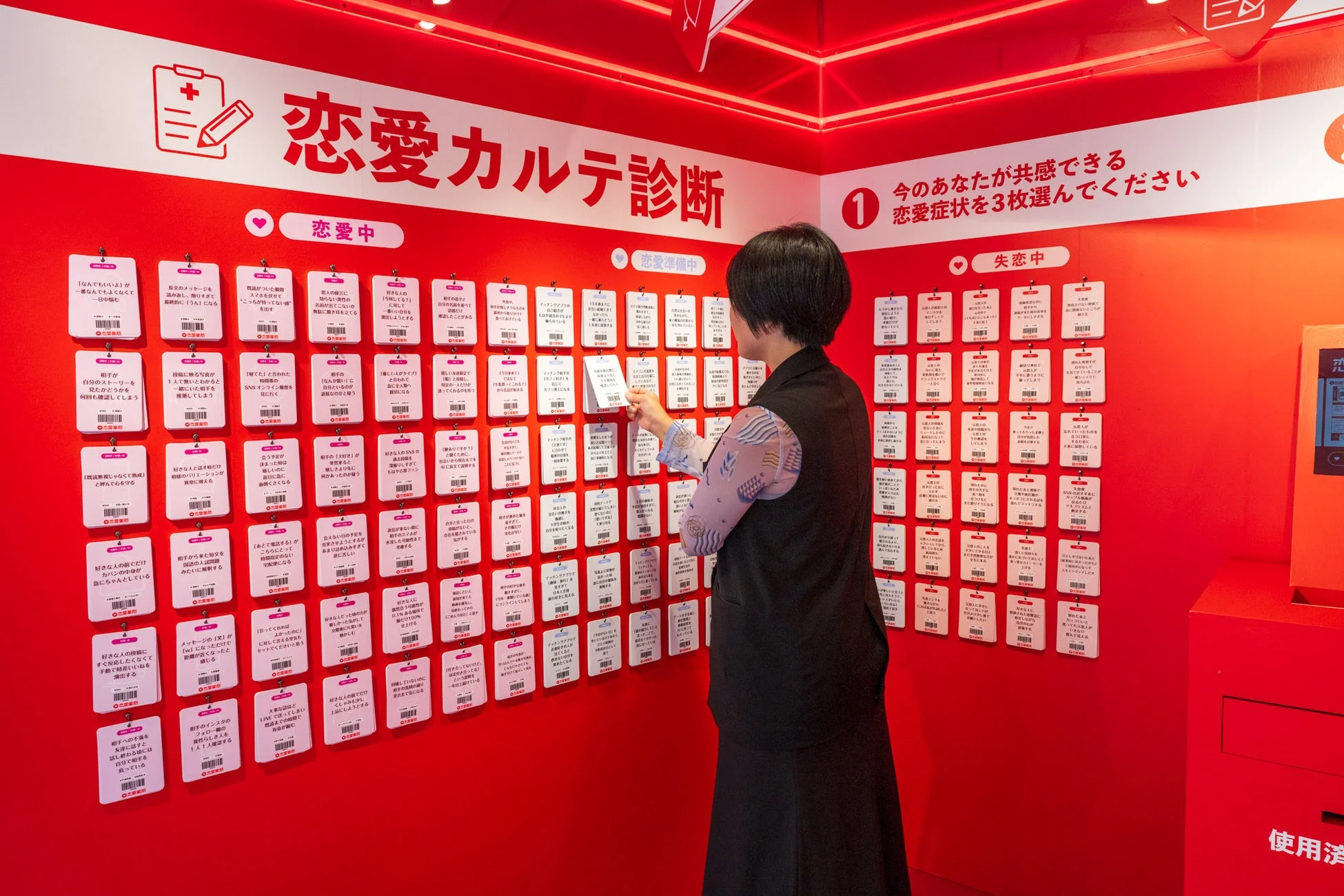恋愛症状カードを選んでいる来場者の様子