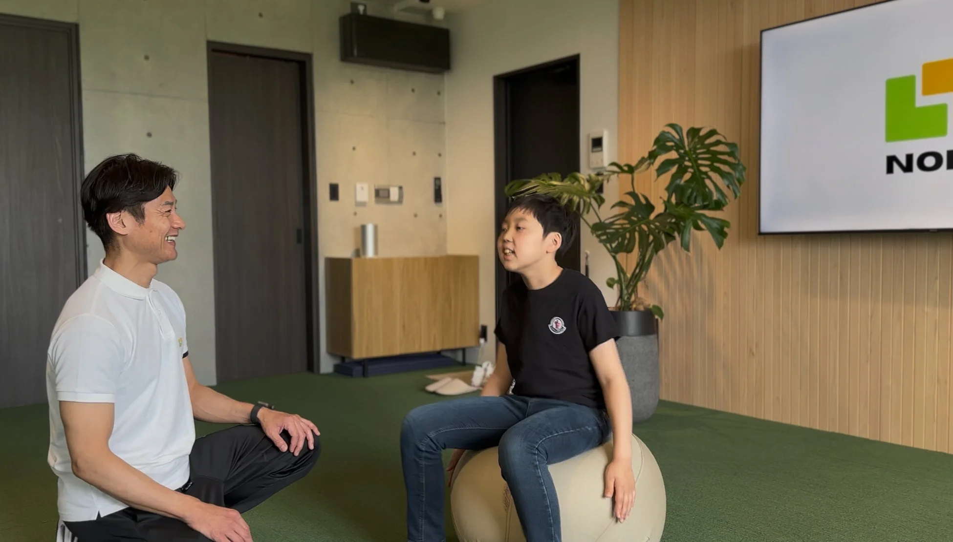 バランスボールの少年と男性